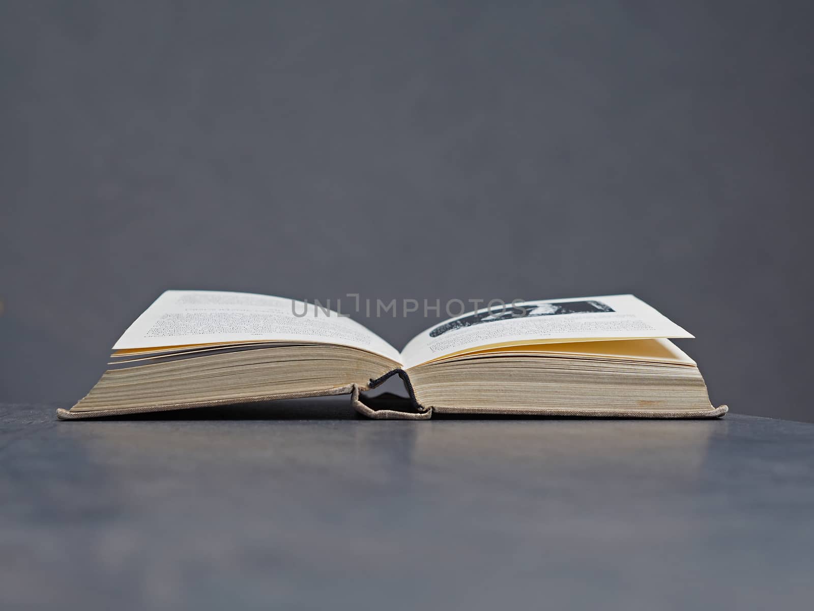 open old book with beige canvas binding, soft grey bacground - reading