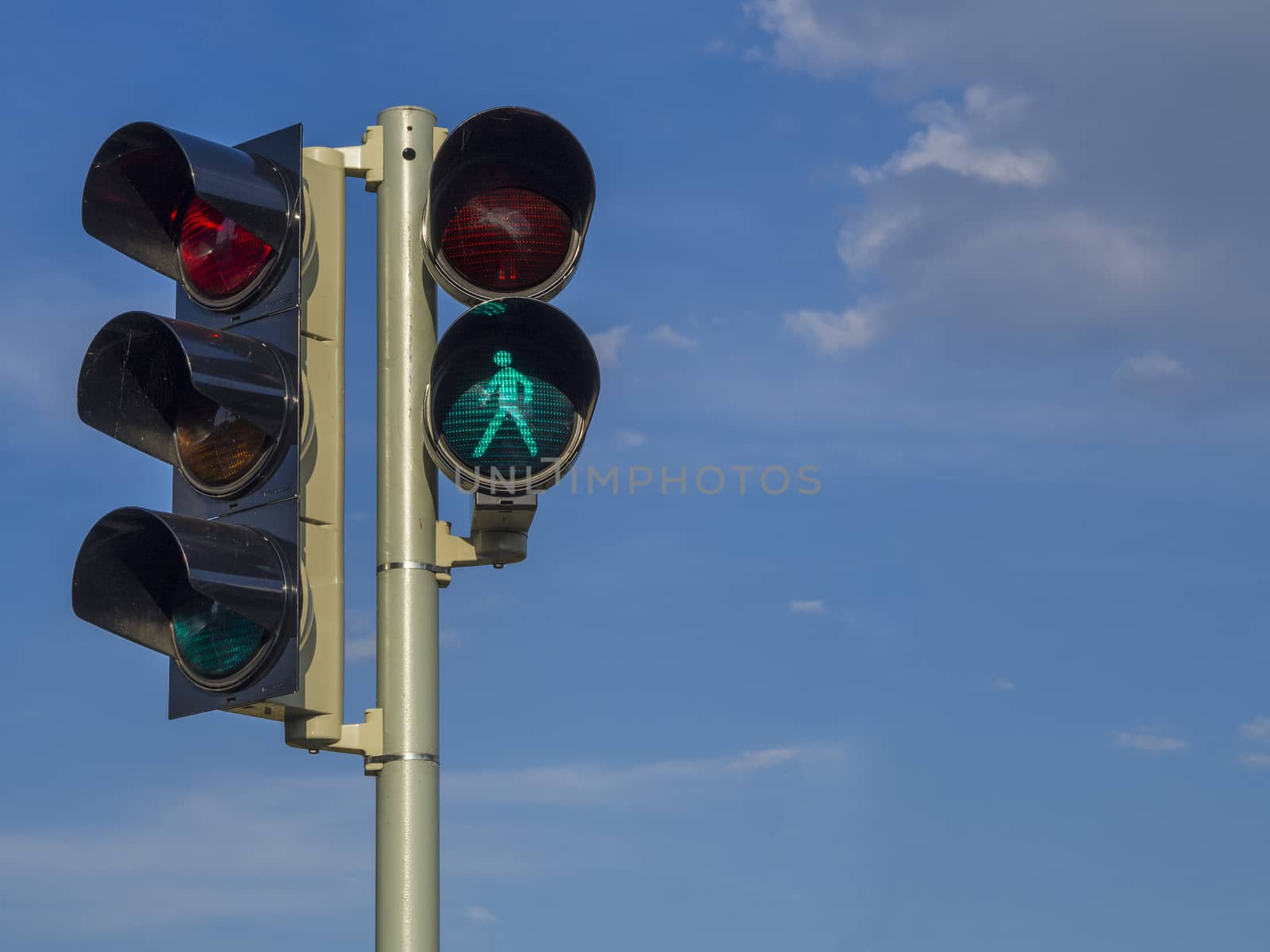 traffic light - semaphore - green walking figure puppet on blue sky background