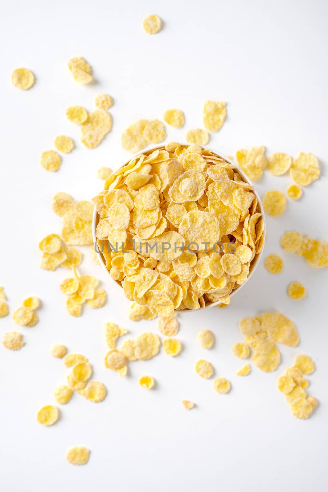 Corn flakes bowl sweeties with milk and orange on white backgrou by ROMIXIMAGE