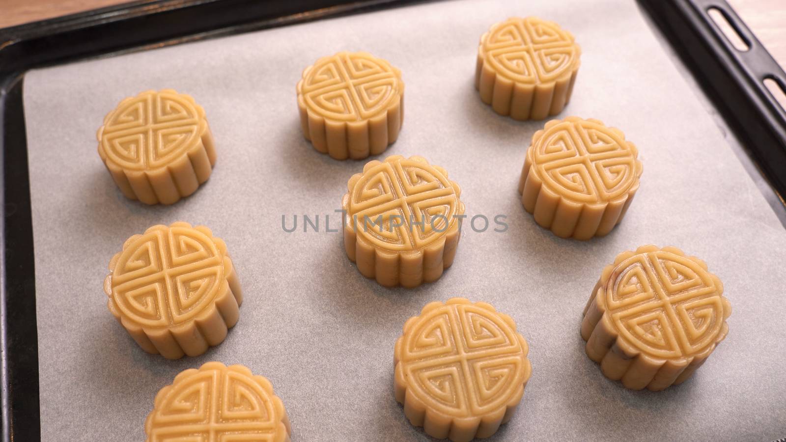Homemade cantonese moon cake pastry on baking tray before baking for traditional festival, close up, lifestyle.