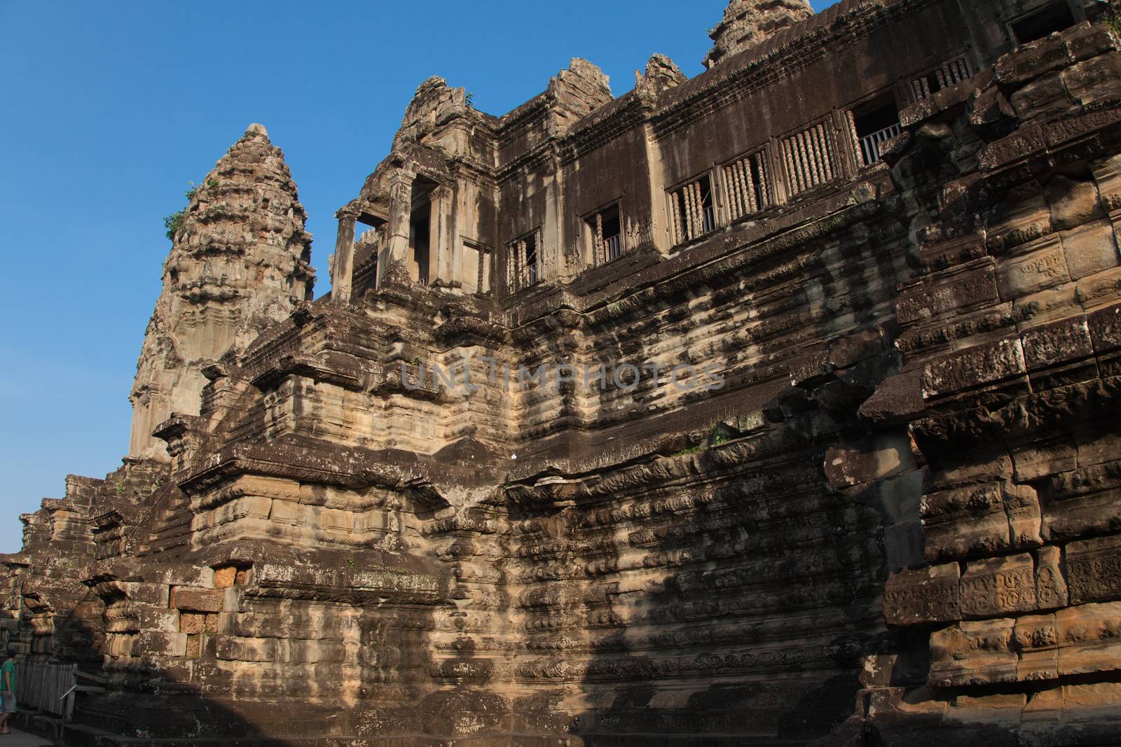 The temple complex of Angkor Watt, Cambodia, early morning sun looking up at towers and stairs. Warm coloured stones carved High quality photo