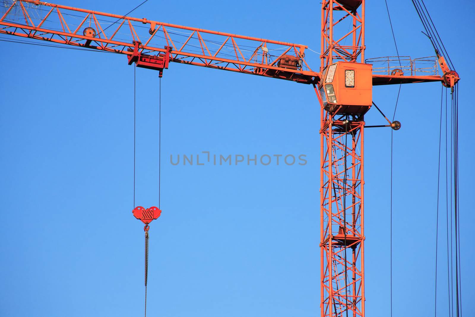 Industrial theme. Red construction crane against blue sky