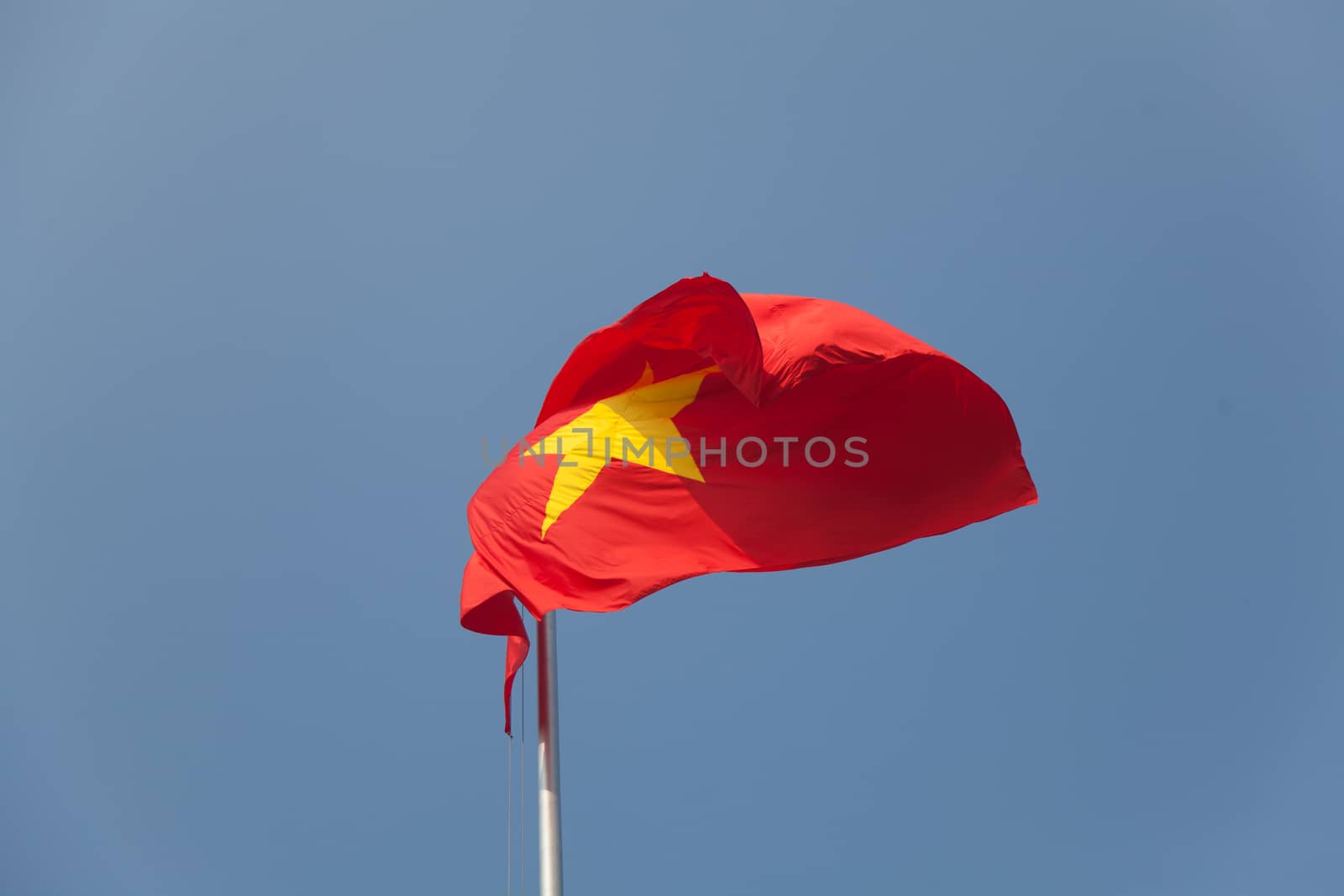 Vietnam national flag blowing in the wind against a perfect blue sky. High quality photo