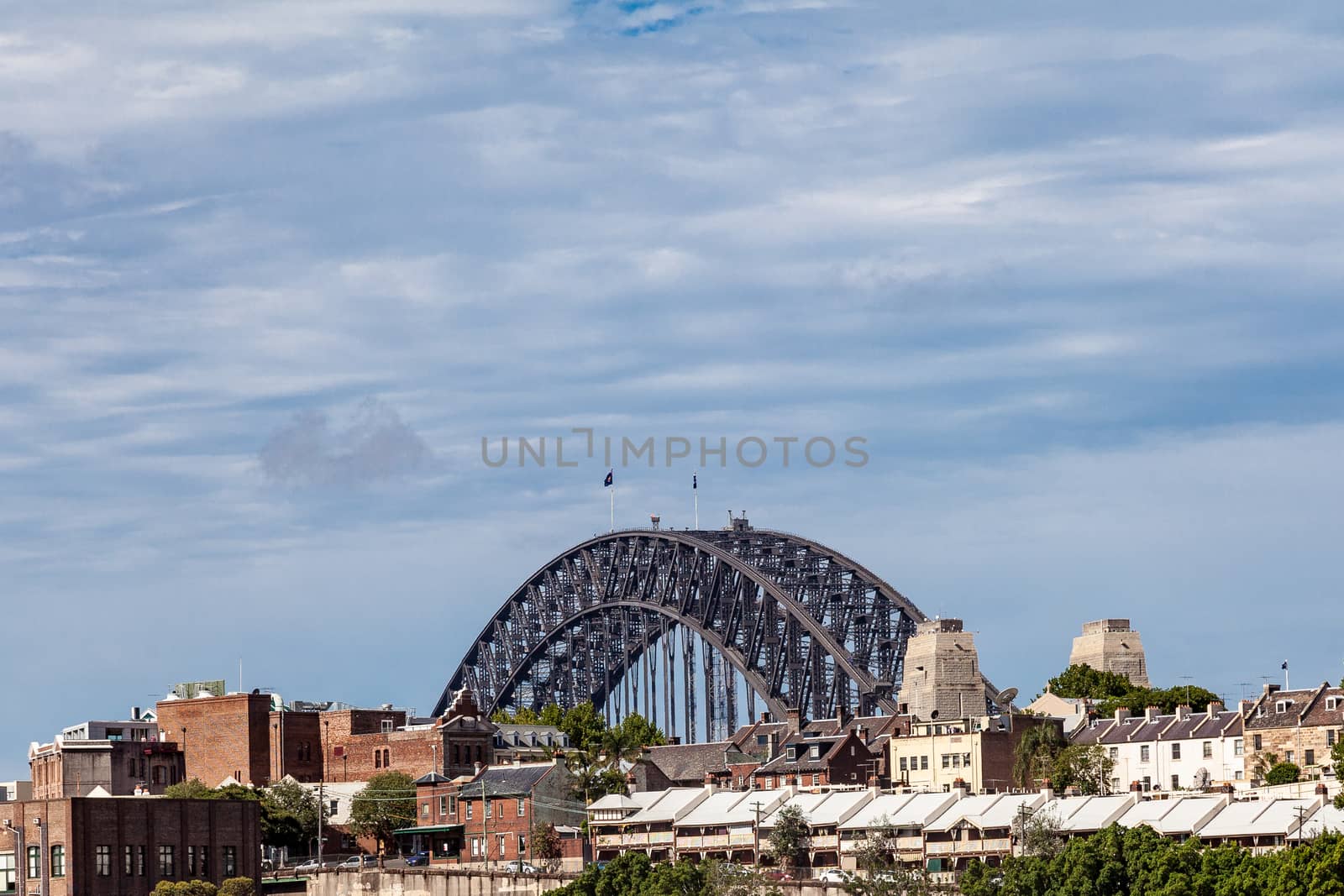 Sydney Harbour a view of the bridge rising above the surrounding buildings by kgboxford