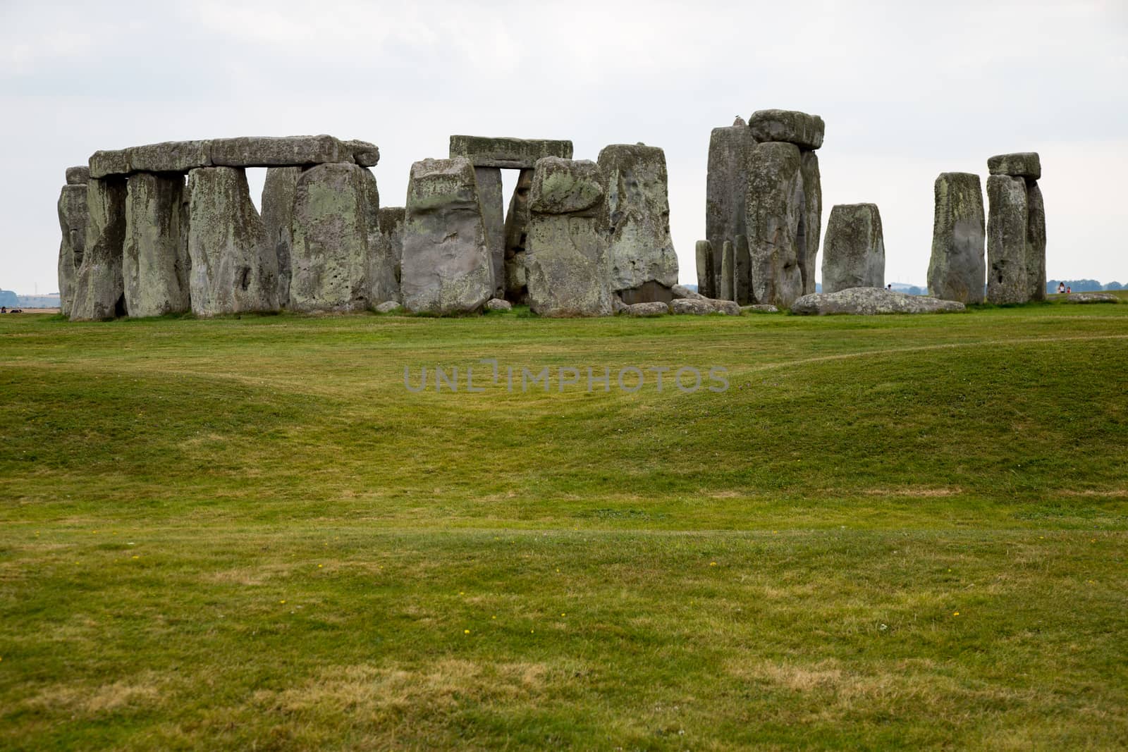 Standing neolithic stones foreground grass midpoint horizon