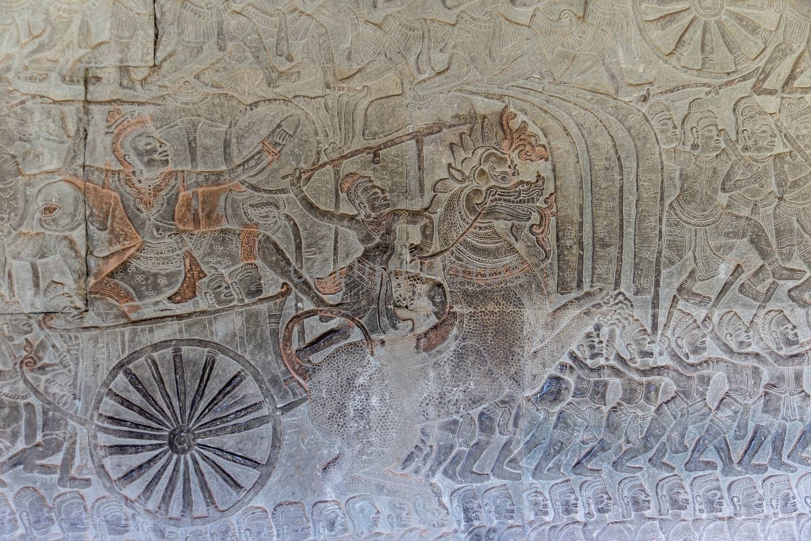 Angkor Watt, Cambodia is a temple complex with hundreds of temples decorated with sculptures, statues and wall reliefs. Many depict gods, kings and times of war. The are shot with side lighting giving texture and details to the subjects wall relief depicting ancient wars. High quality photo