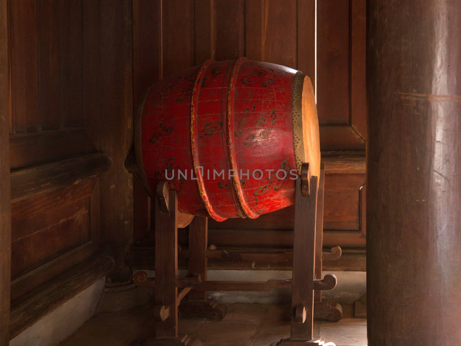 Red wooden drum on frame at entrance to Buddhist temple in Vietnam by kgboxford