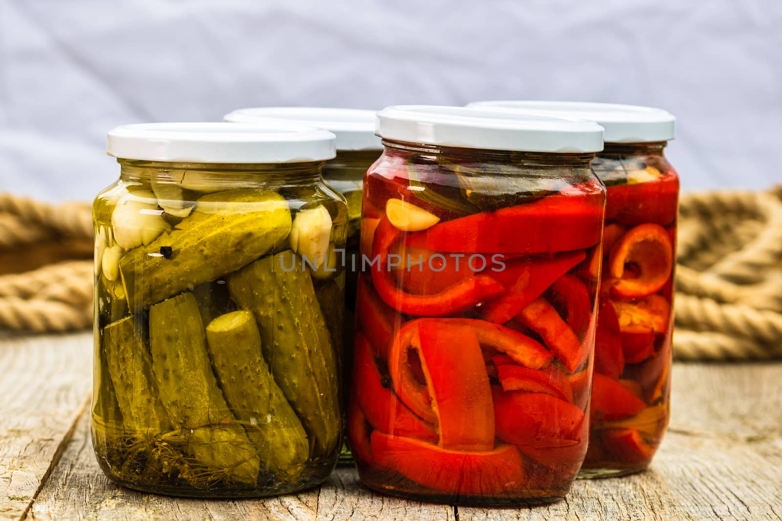 Glass jars with pickled red bell peppers and pickled cucumbers ( by vladispas