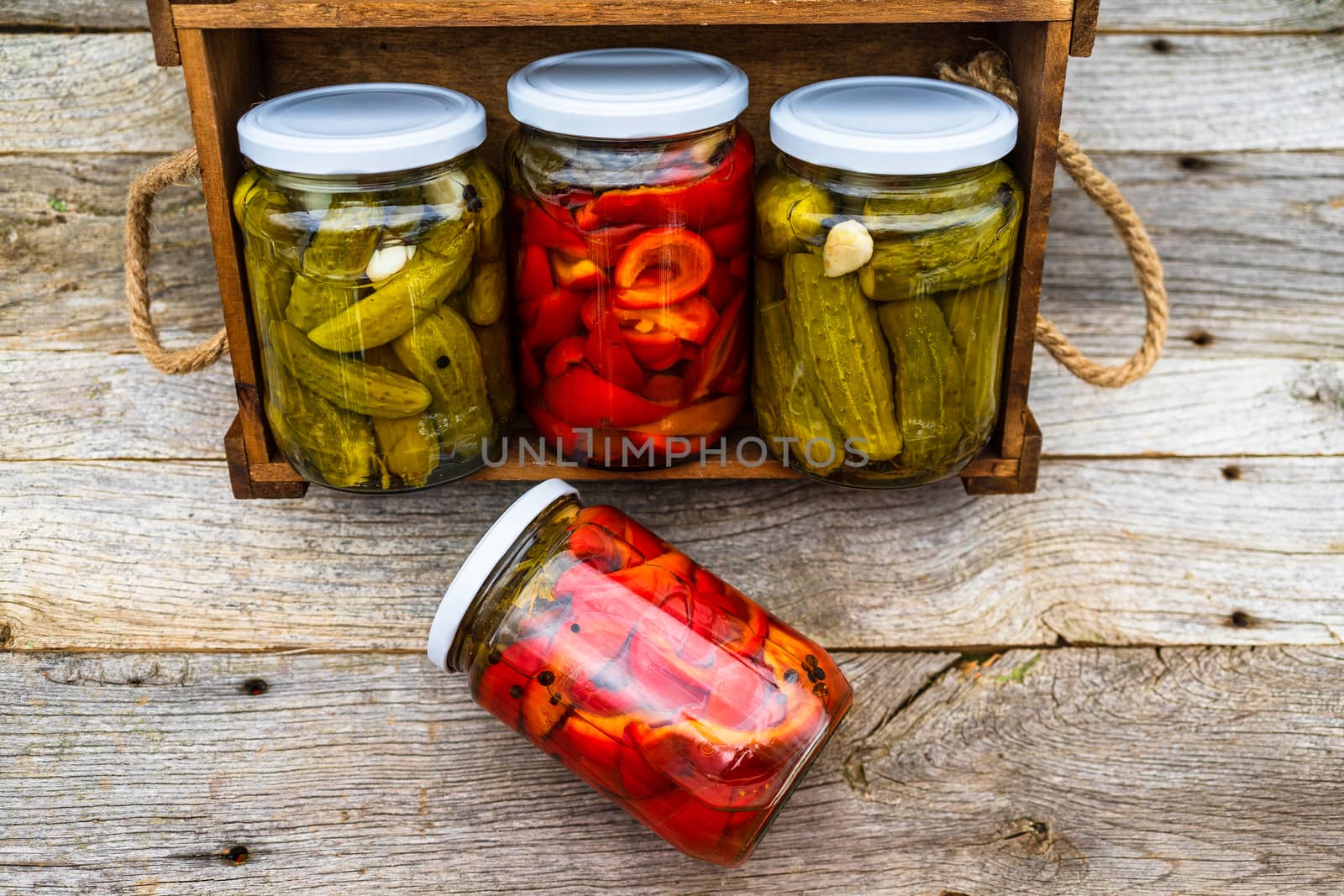 Glass jars with pickled red bell peppers and pickled cucumbers ( by vladispas