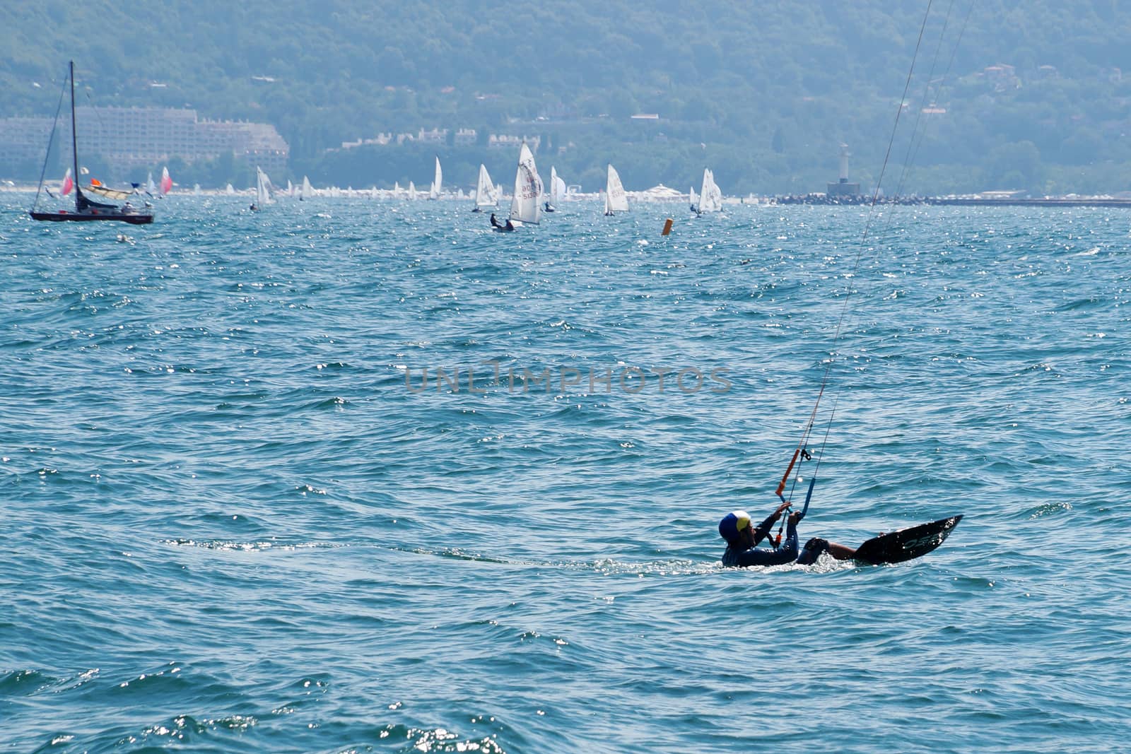 Varna, Bulgaria - July, 19, 2020: a man is kiting the sea on a sunny windy day