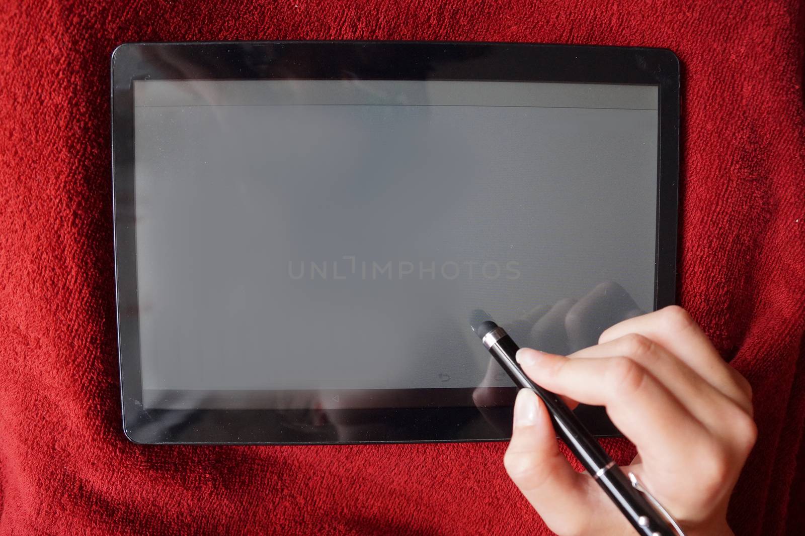 hand writes with a stylus on the white screen of the tablet, mock up