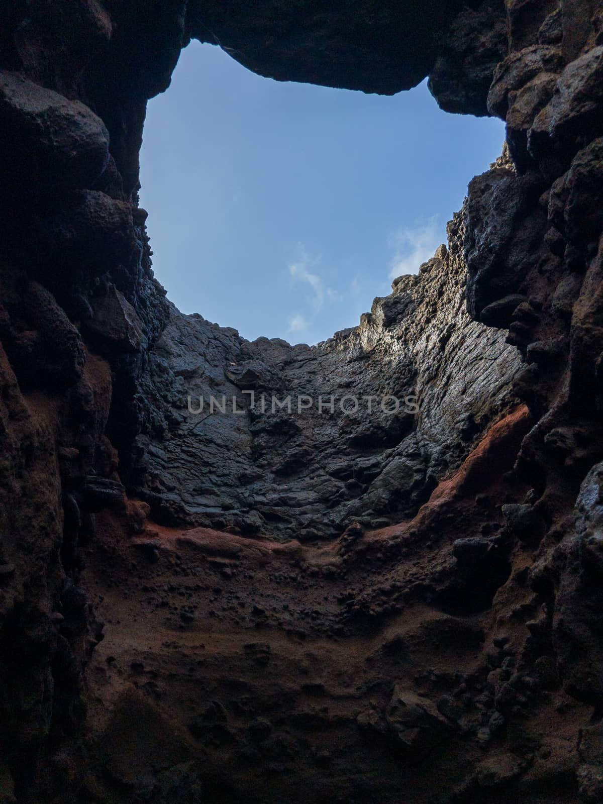 INSIDE OF THE CAVE LOOKING UP AT THE BLUE SKY