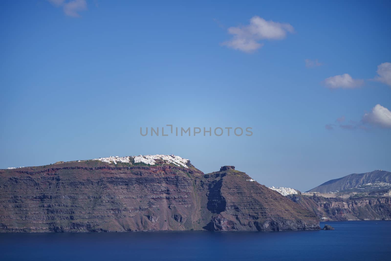 The cliff side of Santorini island and white houses on coastline.