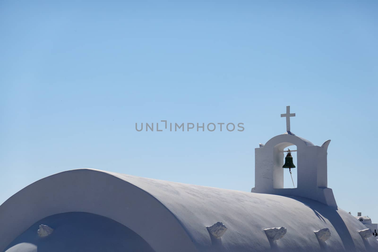 Close up of bell, white church in Oia Santorini, Greece.