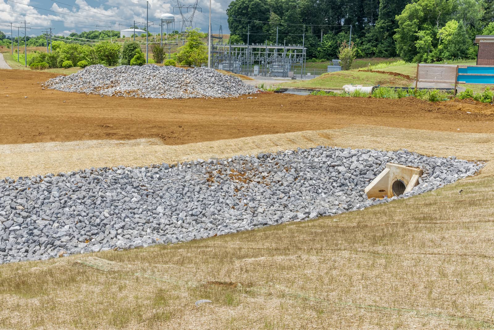 Horizontal shot of a rock lining drainage ditch under construction.