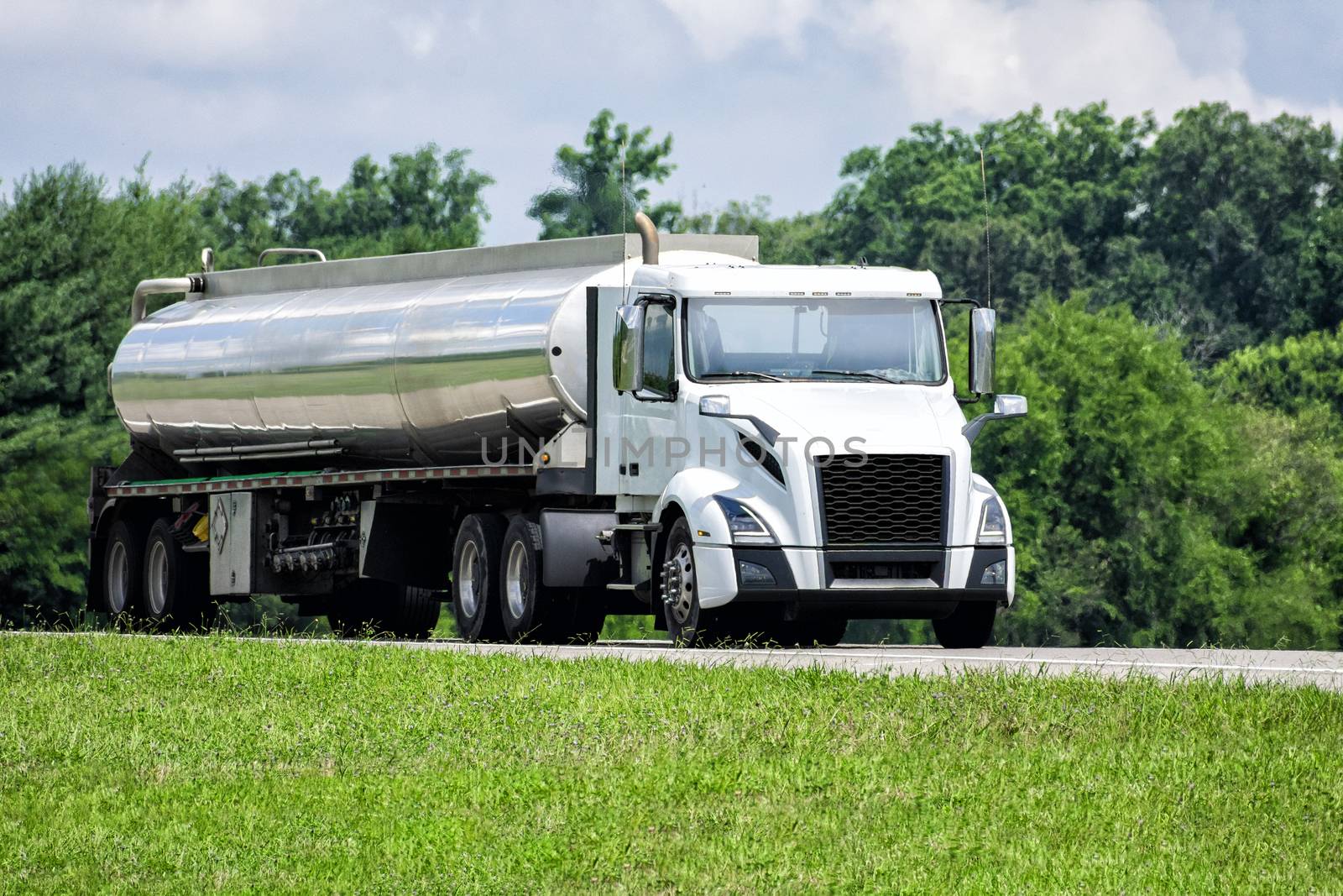 Horizontal shot of an unmarked gasoline delivery tanker truck on the highway.