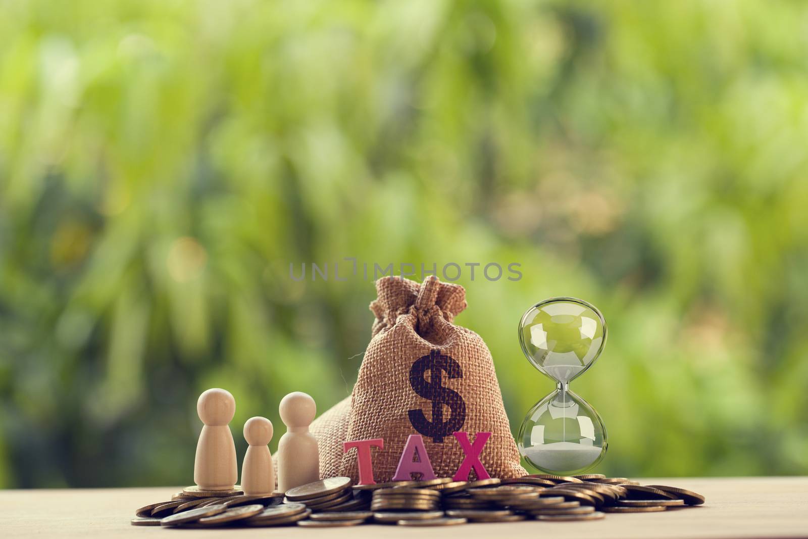 Family members, words tax, hourglass, US money bags on a pile of coins. Family tax benefit, property tax concept: depicts time and income management for future security