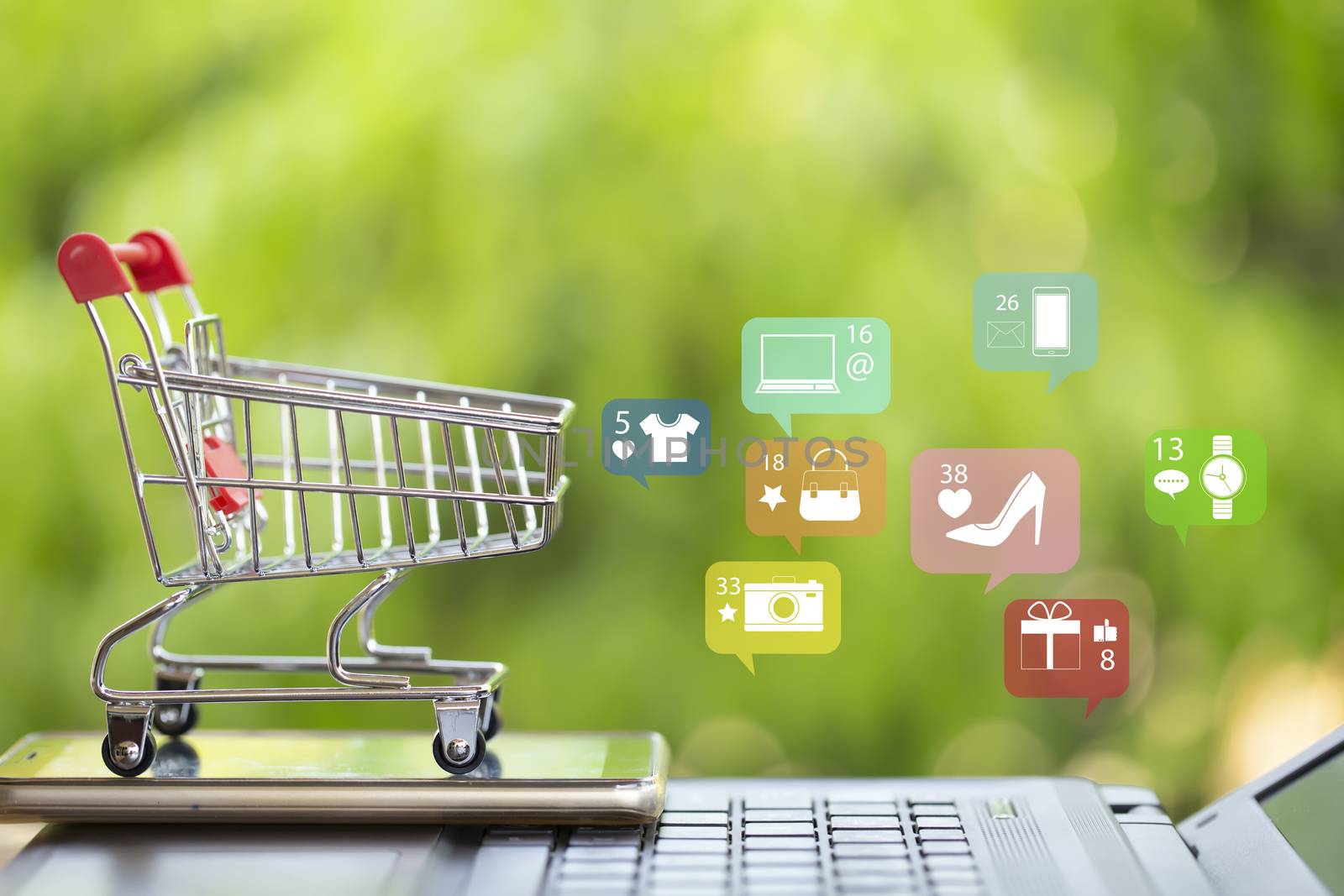 Online marketing and payment concept: Shopping cart with smartphone on laptop computer and icon online shopping and social media networking.