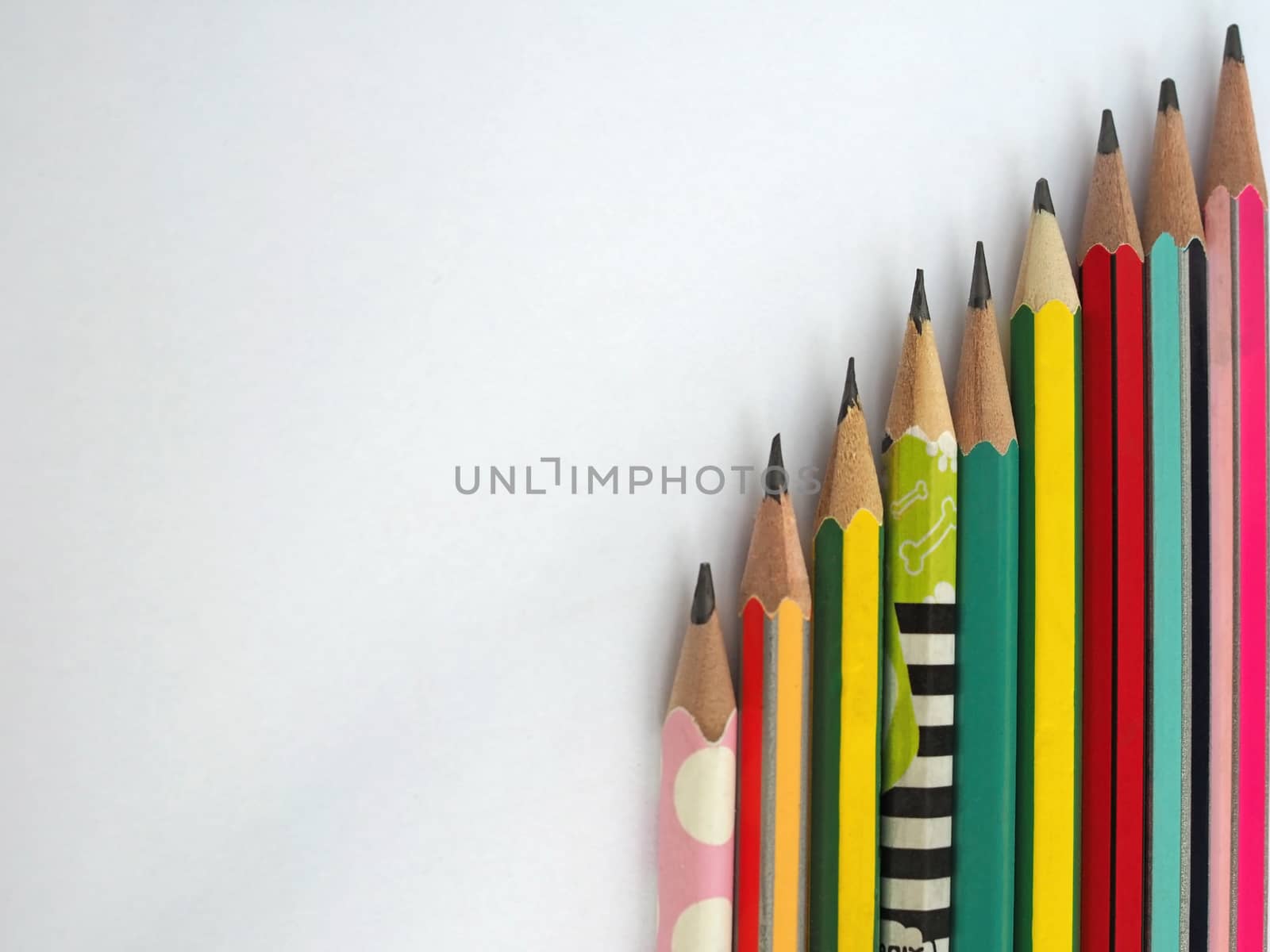flat lay of pencils are arranged vertically on a white background.