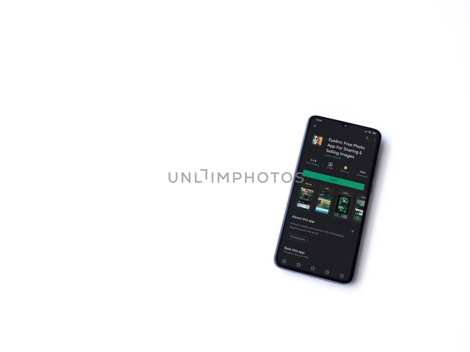 Lod, Israel - July 8, 2020: EyeEm - Sharing & Selling Images app play store page on the display of a black mobile smartphone isolated on white background. Top view flat lay with copy space.