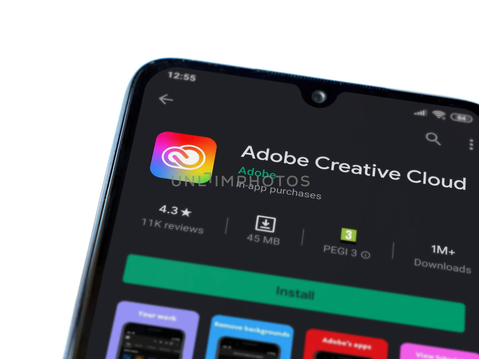 Lod, Israel - July 8, 2020: Adobe Creative Cloud app play store page on the display of a black mobile smartphone isolated on white background. Top view flat lay with copy space.