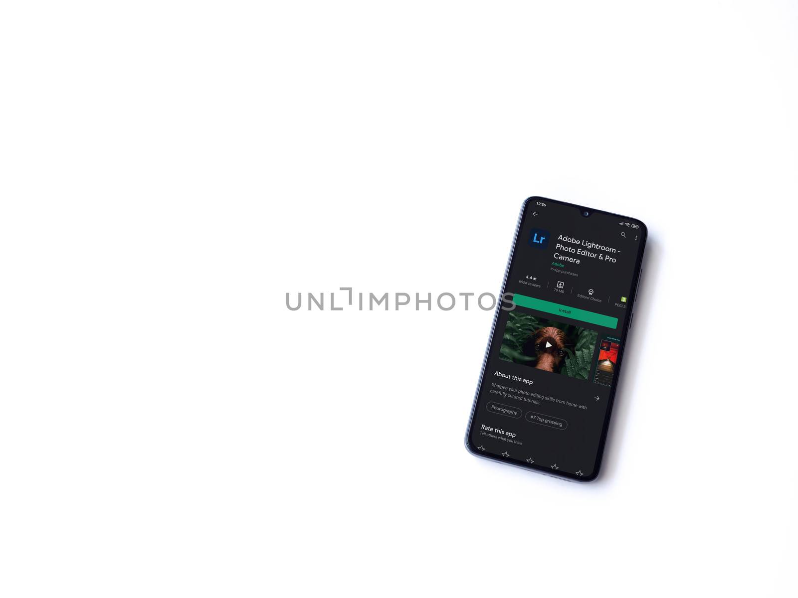 Lod, Israel - July 8, 2020: Adobe Lightroom - Photo Editor & Pro Camera app play store page on the display of a black mobile smartphone isolated on white background. Top view flat lay with copy space.