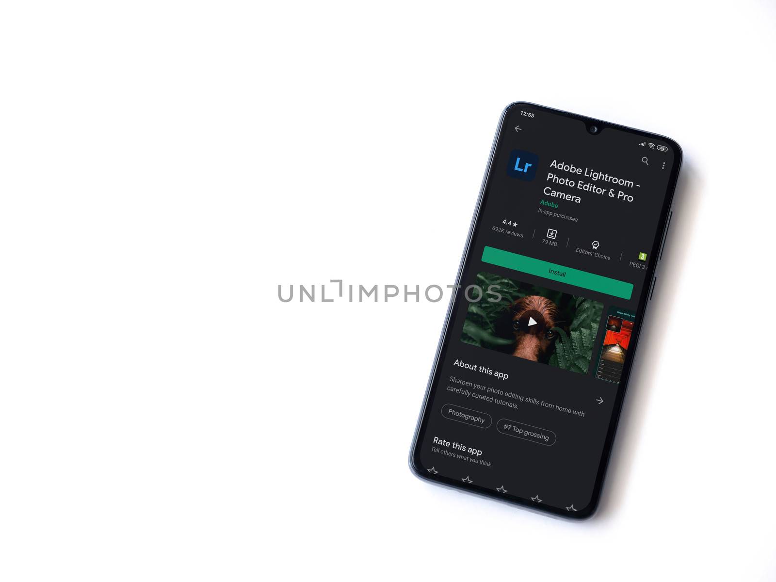 Lod, Israel - July 8, 2020: Adobe Lightroom - Photo Editor & Pro Camera app play store page on the display of a black mobile smartphone isolated on white background. Top view flat lay with copy space.