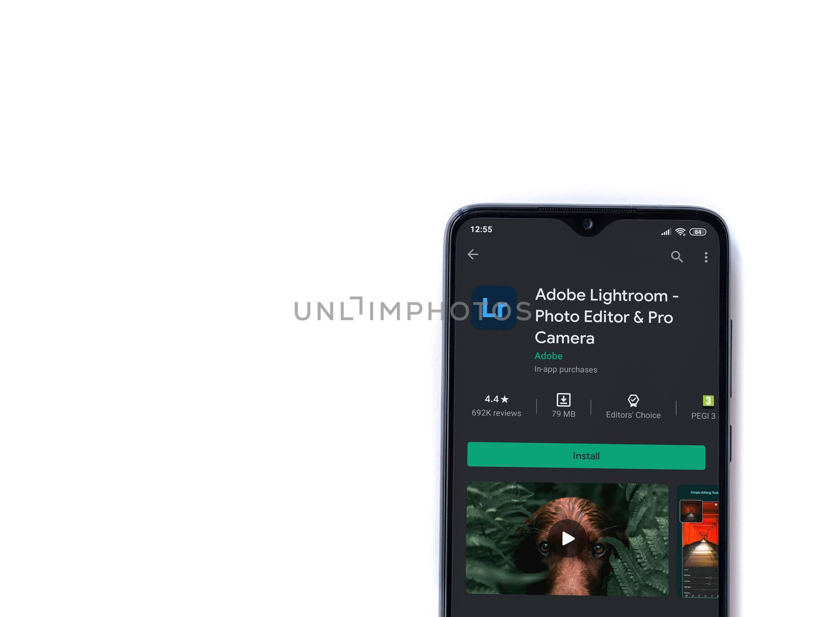 Lod, Israel - July 8, 2020: Adobe Lightroom - Photo Editor & Pro Camera app play store page on the display of a black mobile smartphone isolated on white background. Top view flat lay with copy space.