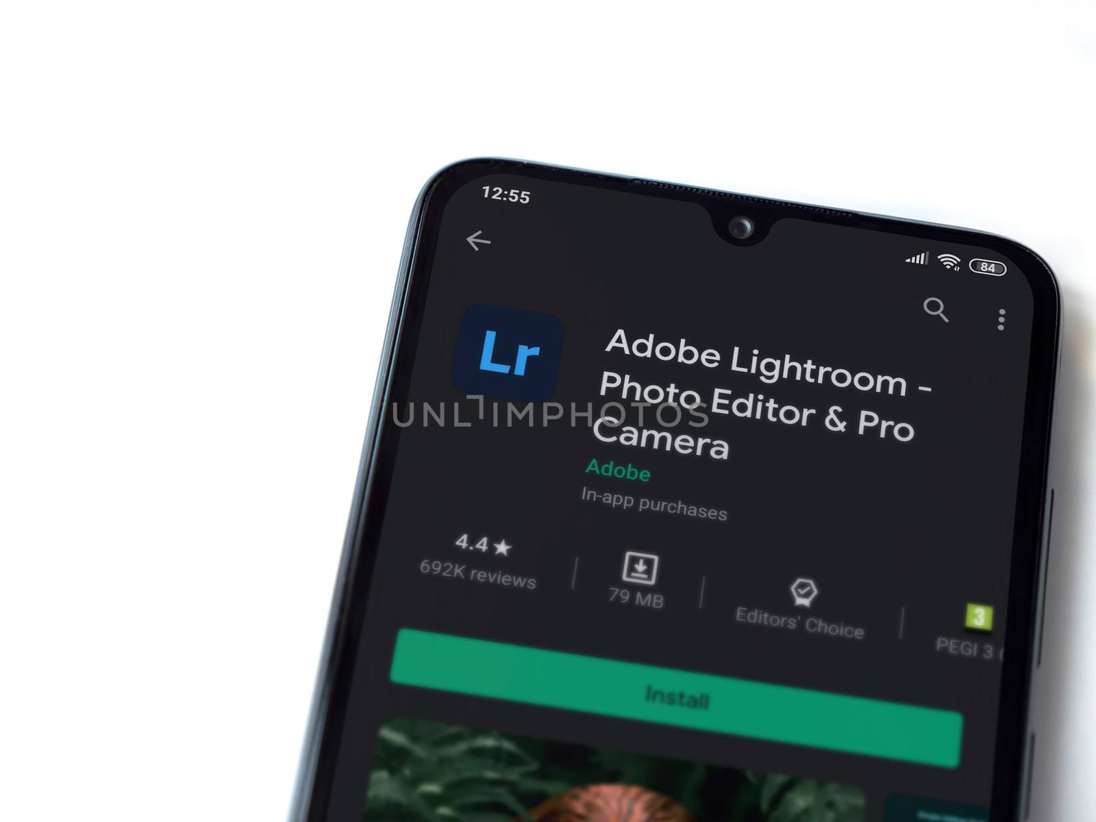 Lod, Israel - July 8, 2020: Adobe Lightroom - Photo Editor & Pro Camera app play store page on the display of a black mobile smartphone isolated on white background. Top view flat lay with copy space.