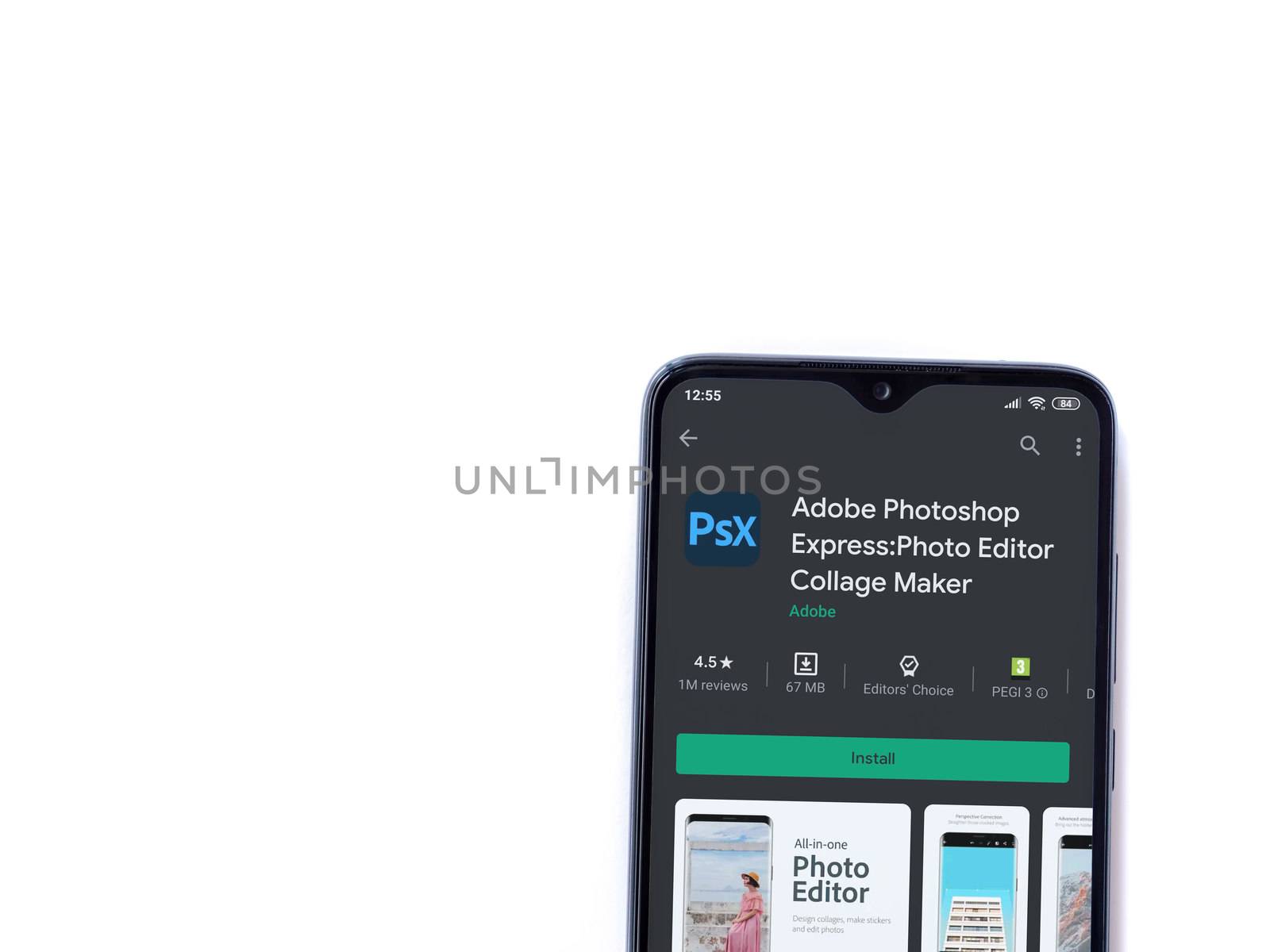 Lod, Israel - July 8, 2020: Adobe Photoshop Express Photo Editor app play store page on the display of a black mobile smartphone isolated on white background. Top view flat lay with copy space.
