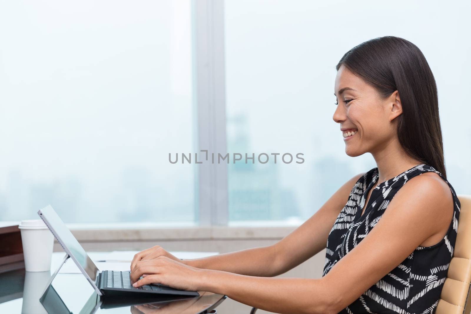 Asian business woman using laptop at work or home office by Maridav