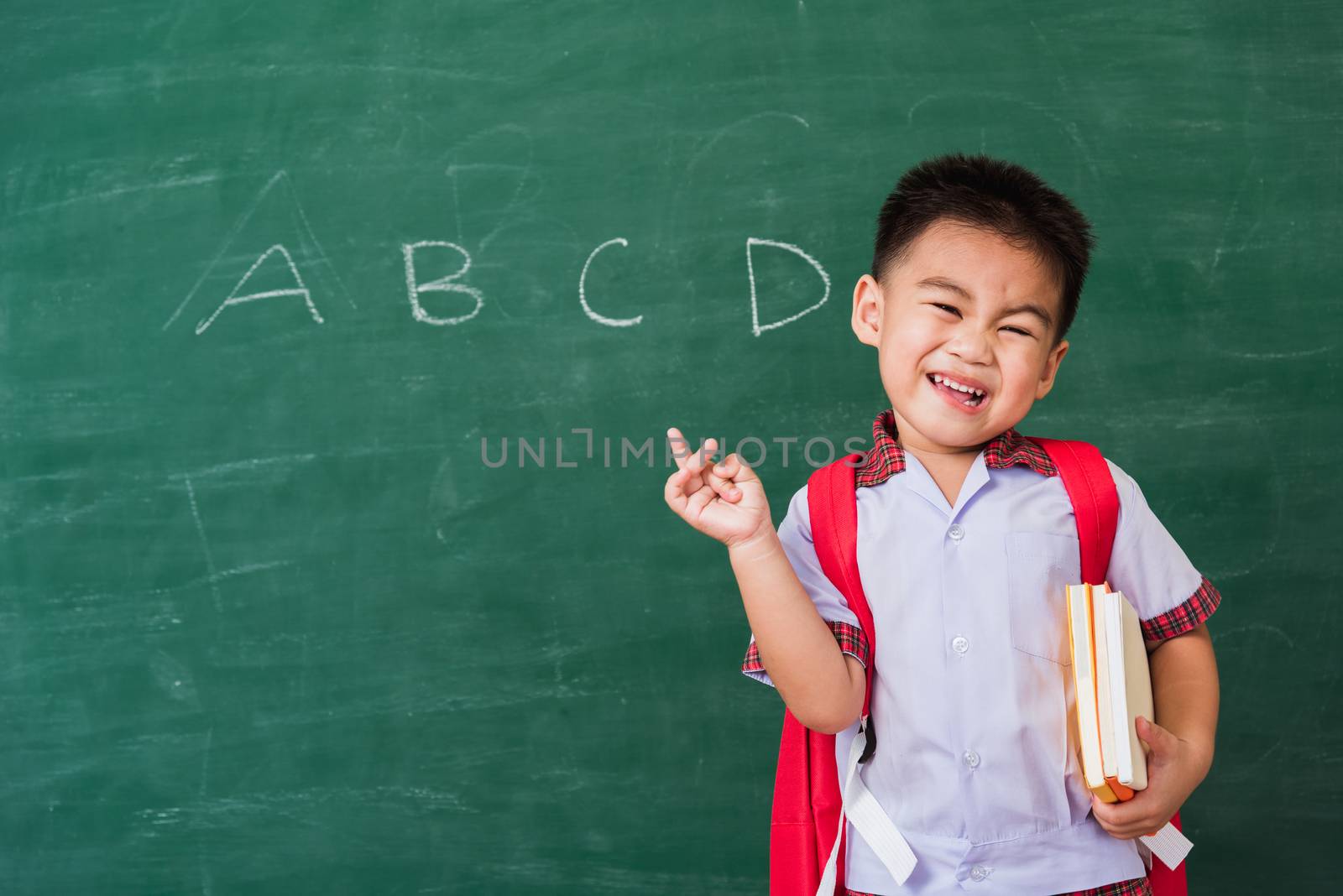 Child boy from kindergarten in student uniform with school bag a by Sorapop