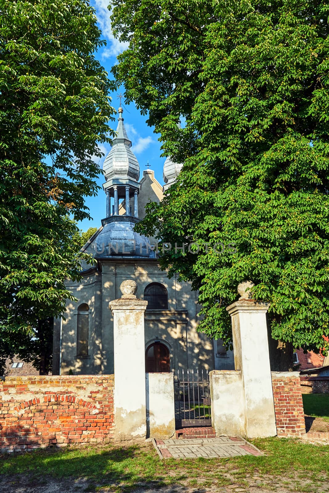 historic parish church with two bell towers in the village of Stary Dworek in Poland