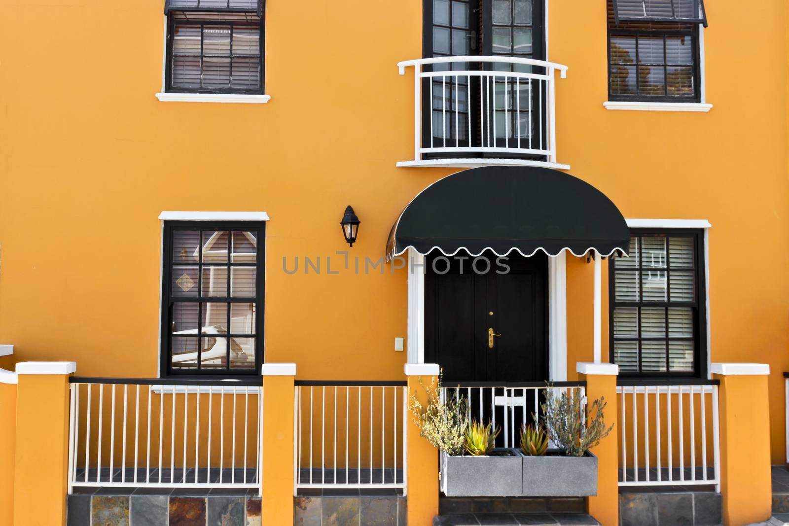 Beautiful African orange house with windows and door texture in Bo-Kaap, Schotsche Kloof.