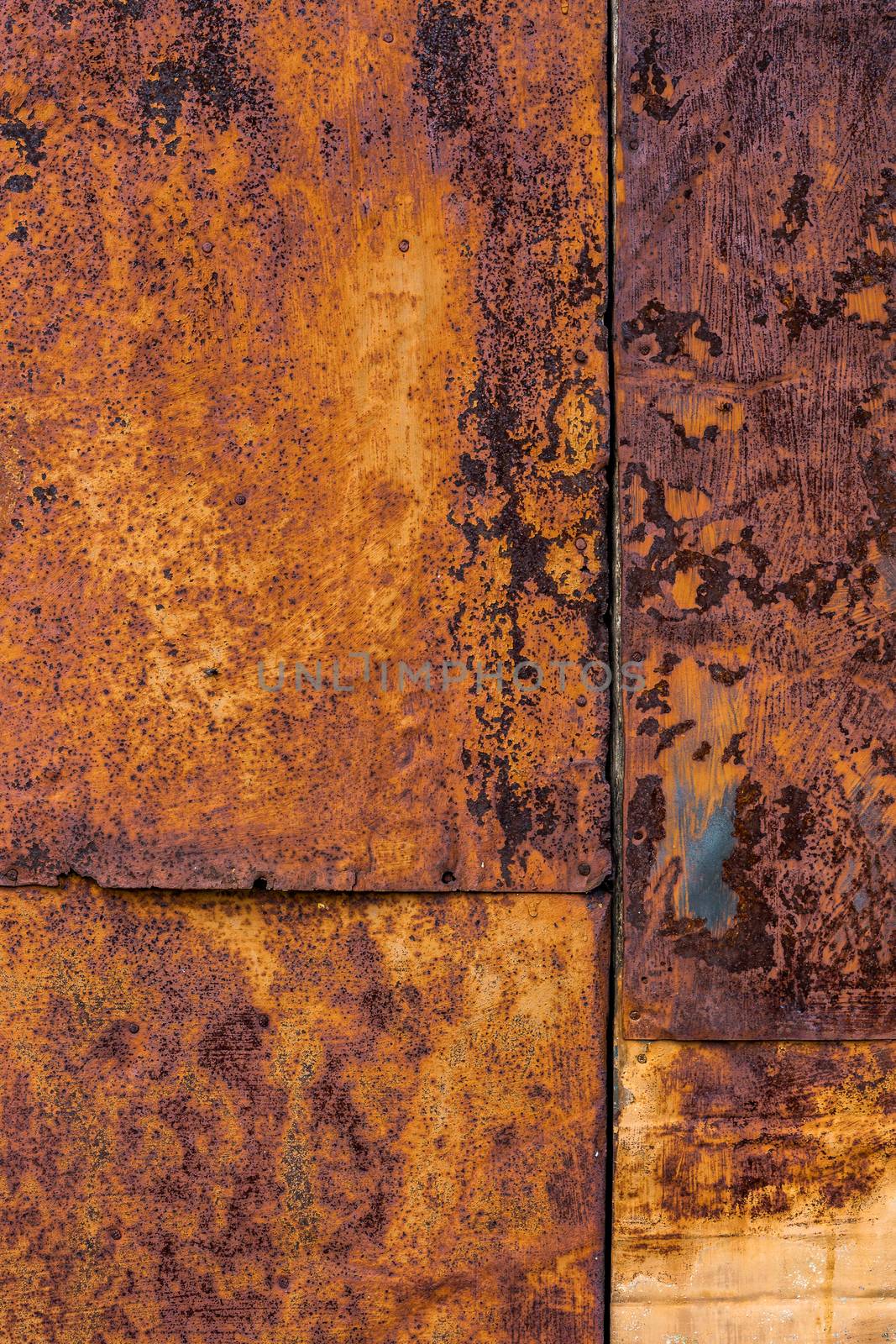 Four nailed rusted iron sheets flat background and texture, vertical shot.
