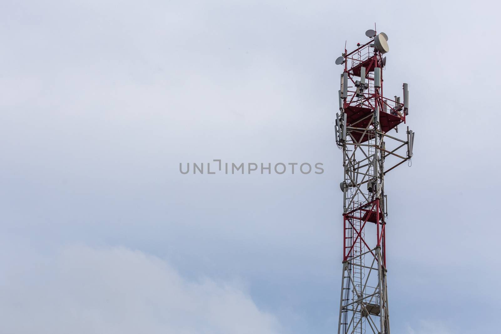 3G, 4G, 5G, wireless and cell phone telecommunication tower close-up on cloudy daylight sky background with copy space by z1b