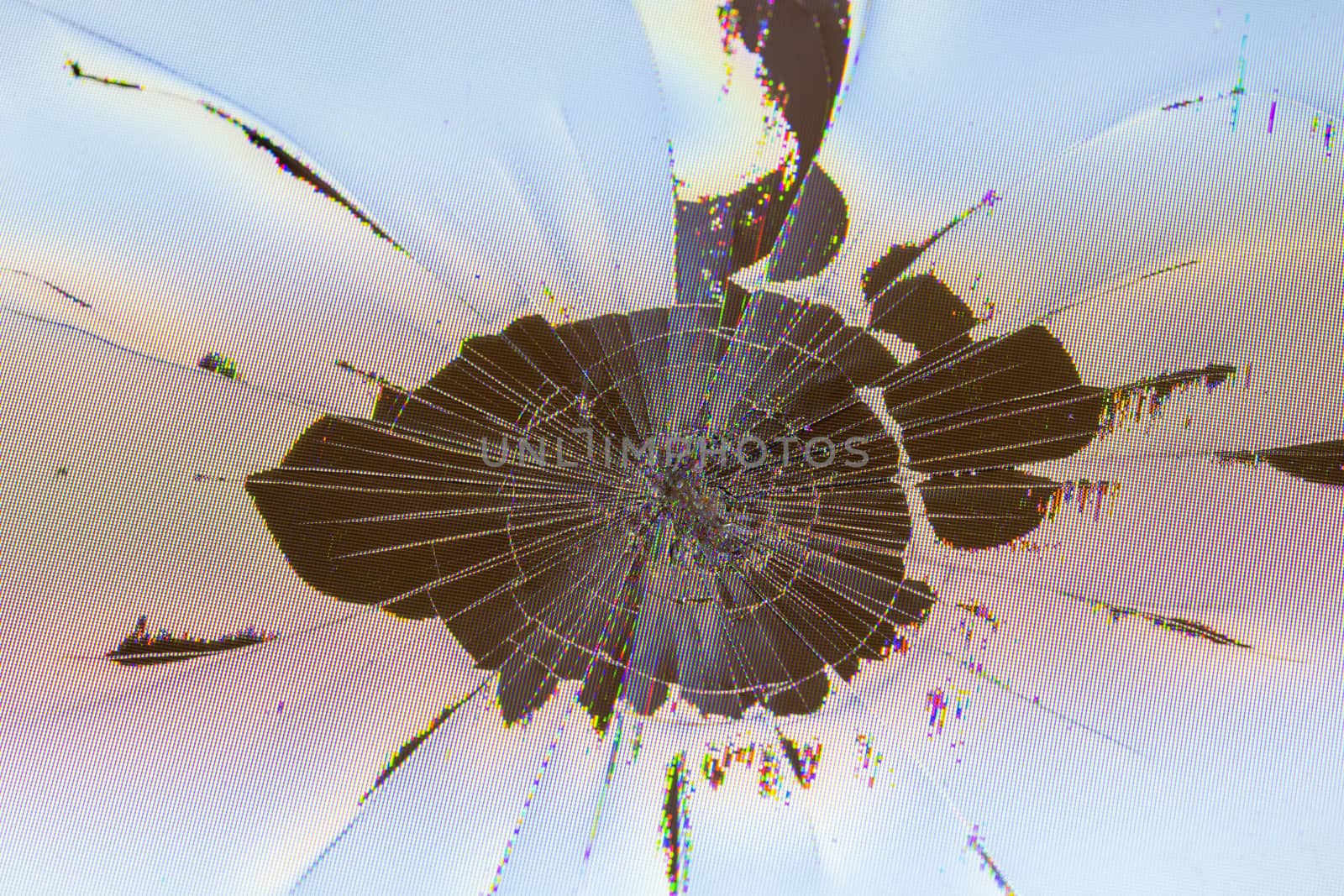 close-up view of physically damaged lcd screen surface with impact spot, radial cracks, pixel grid leakage and discoloration.