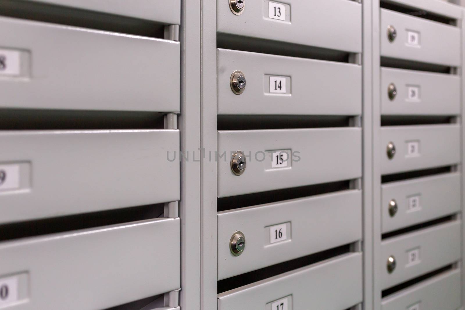 gray mailboxes on the landing of russian condominium - close-up view with selective focus and linear perspective