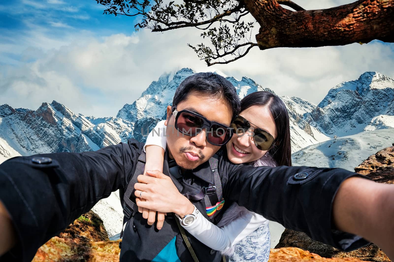 Young Couple in sunglasses Tourists on Hight snow mountain in China