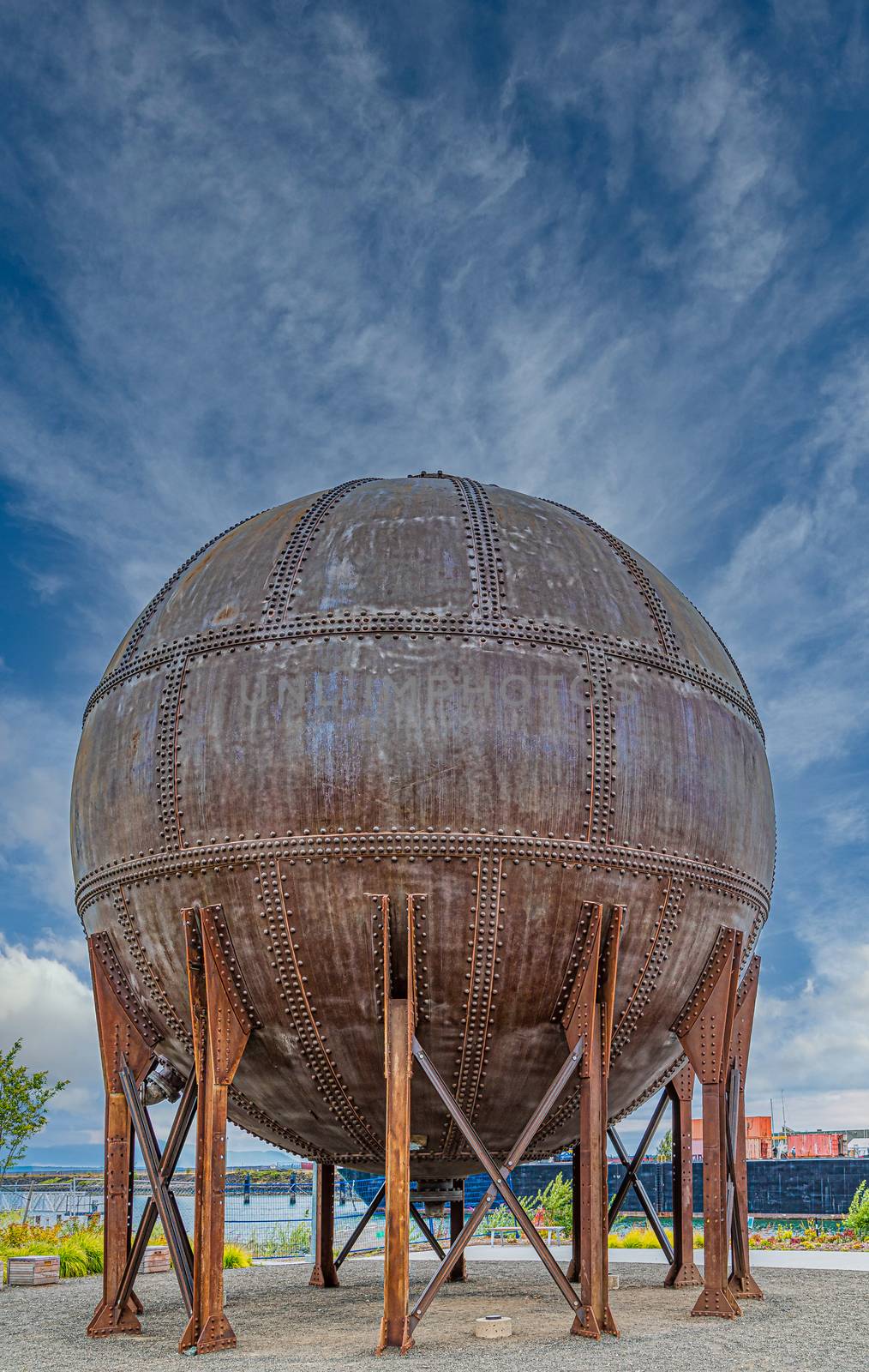 Round Rusty Tank with Rivets on Sky by dbvirago