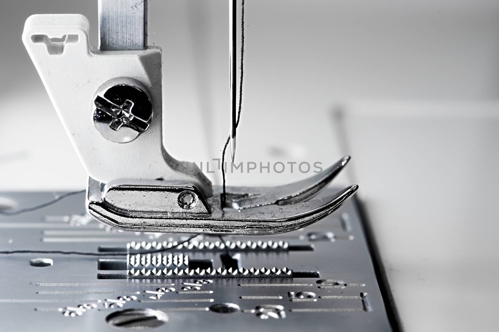 5 - Macro sewing machine side view with flat foot plate ready to stitch.