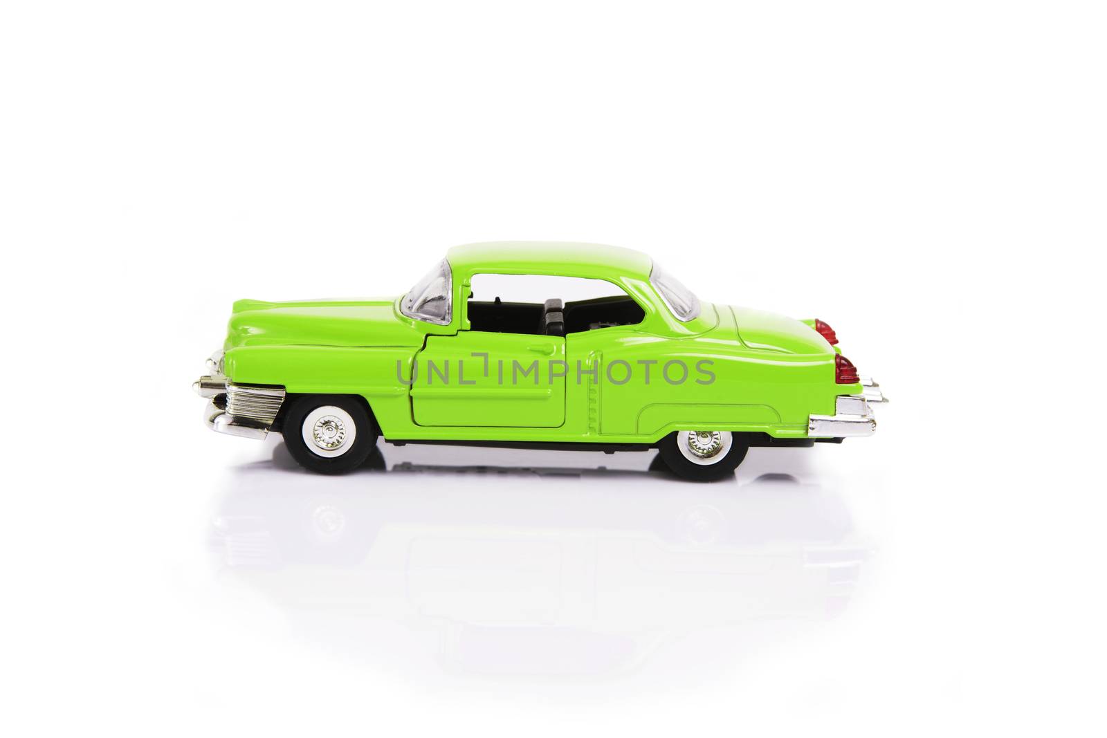 Side view of green model toy car in retro style on white background.