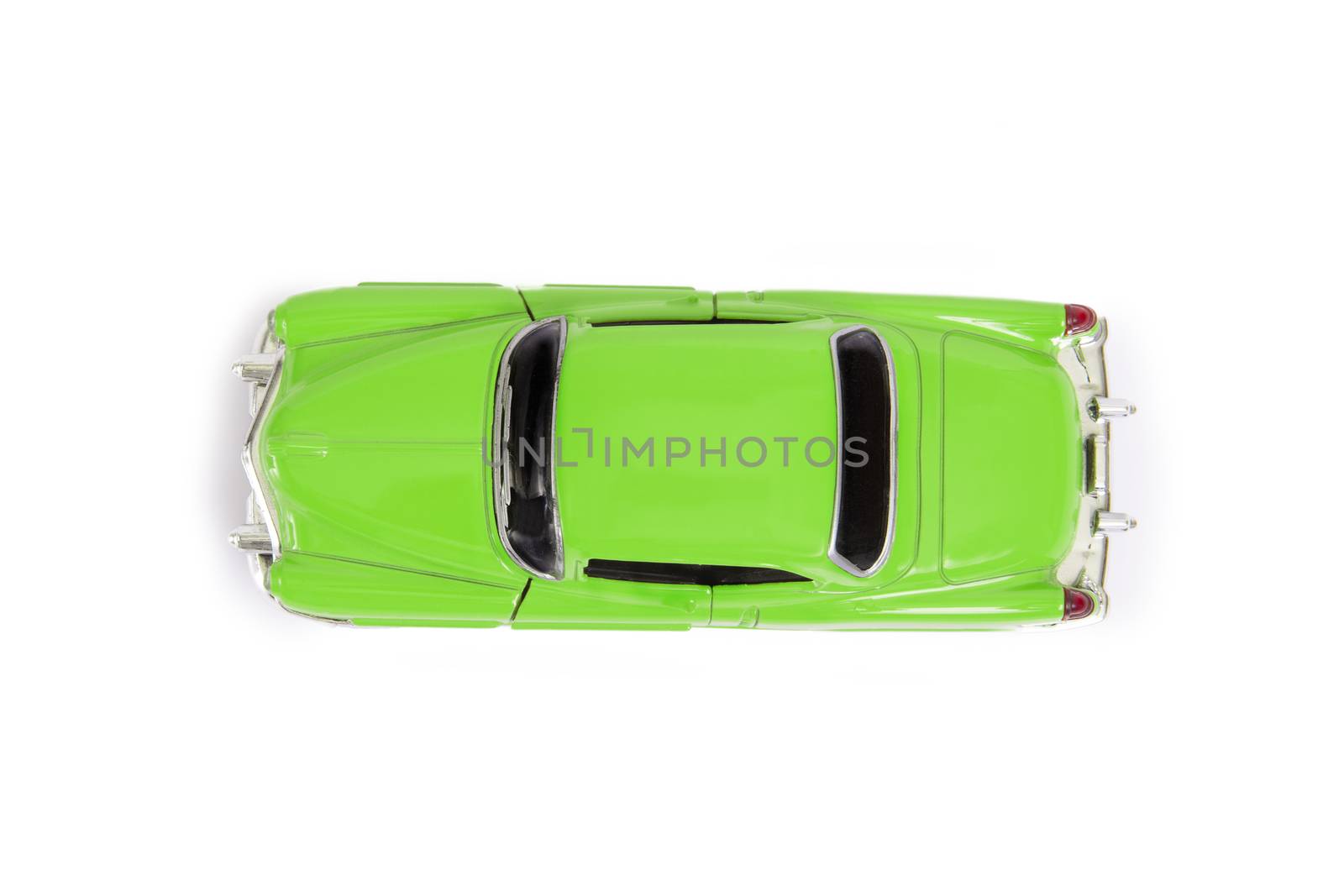 Top view of green model toy car in retro style on white background.