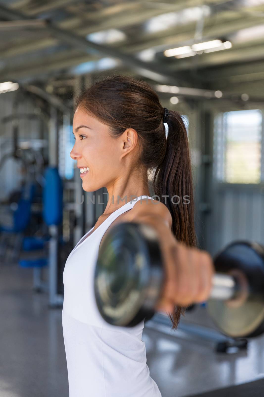 Gym woman fitness training arms lifting free weights. Dumbbell lateral raise shoulder workout.