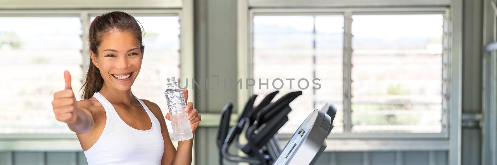 Happy girl drinking water at fitness center banner by Maridav