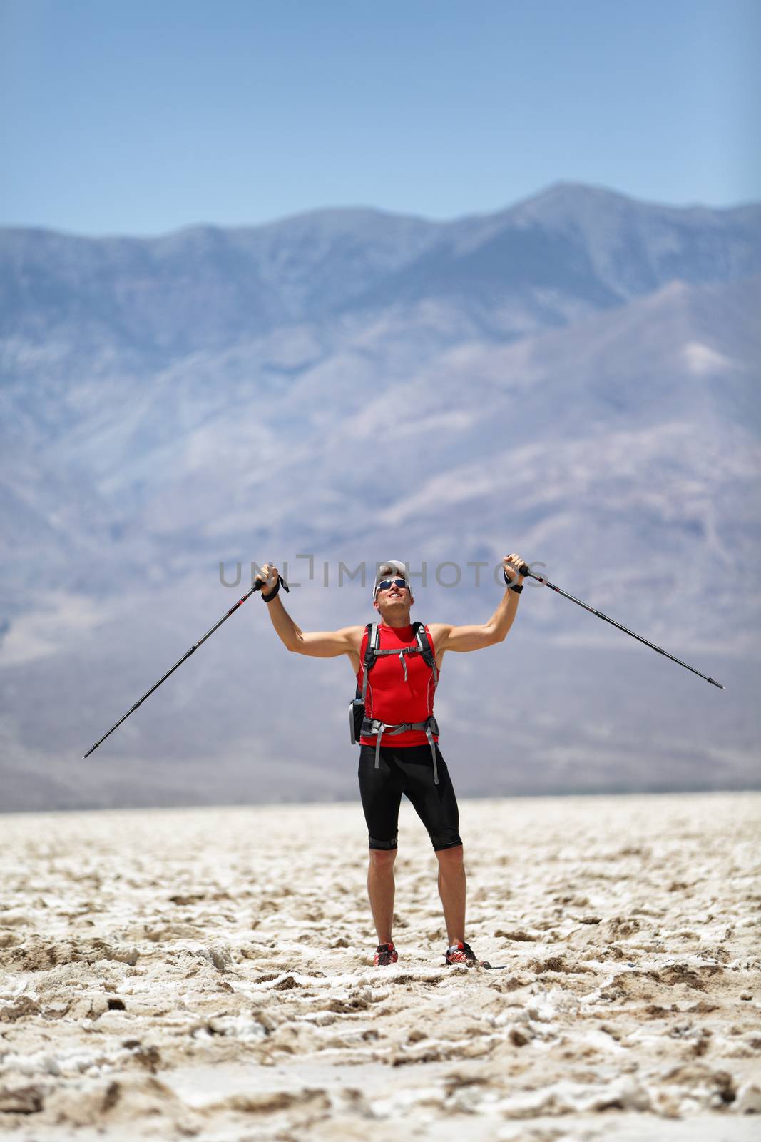 Hiker Holding Poles Against Mountain by Maridav