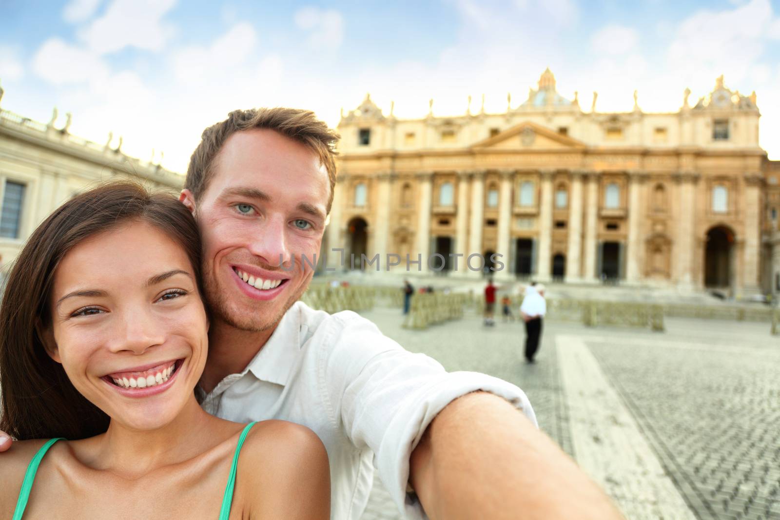 Happy couple against St. Peter's Basilica church in Rome. Portrait of cheerful man and woman enjoying their holidays. Male and female tourists are in Vatican city.