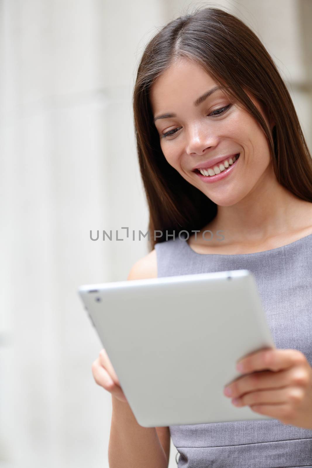 Smiling young Business woman using digital tablet at work. Asian businesswoman Happy surfing internet holding smart device laptop tablet computer. Chinese professional at cafe or office.