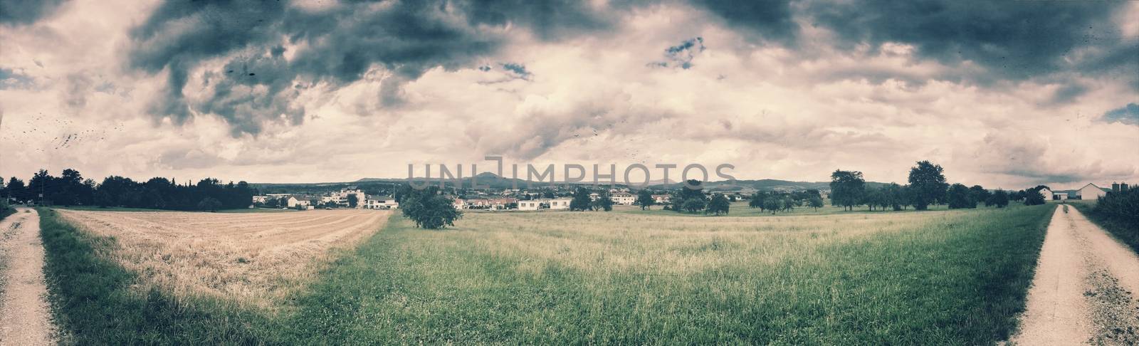 panoramic view over green with dark clouds in vintage look
