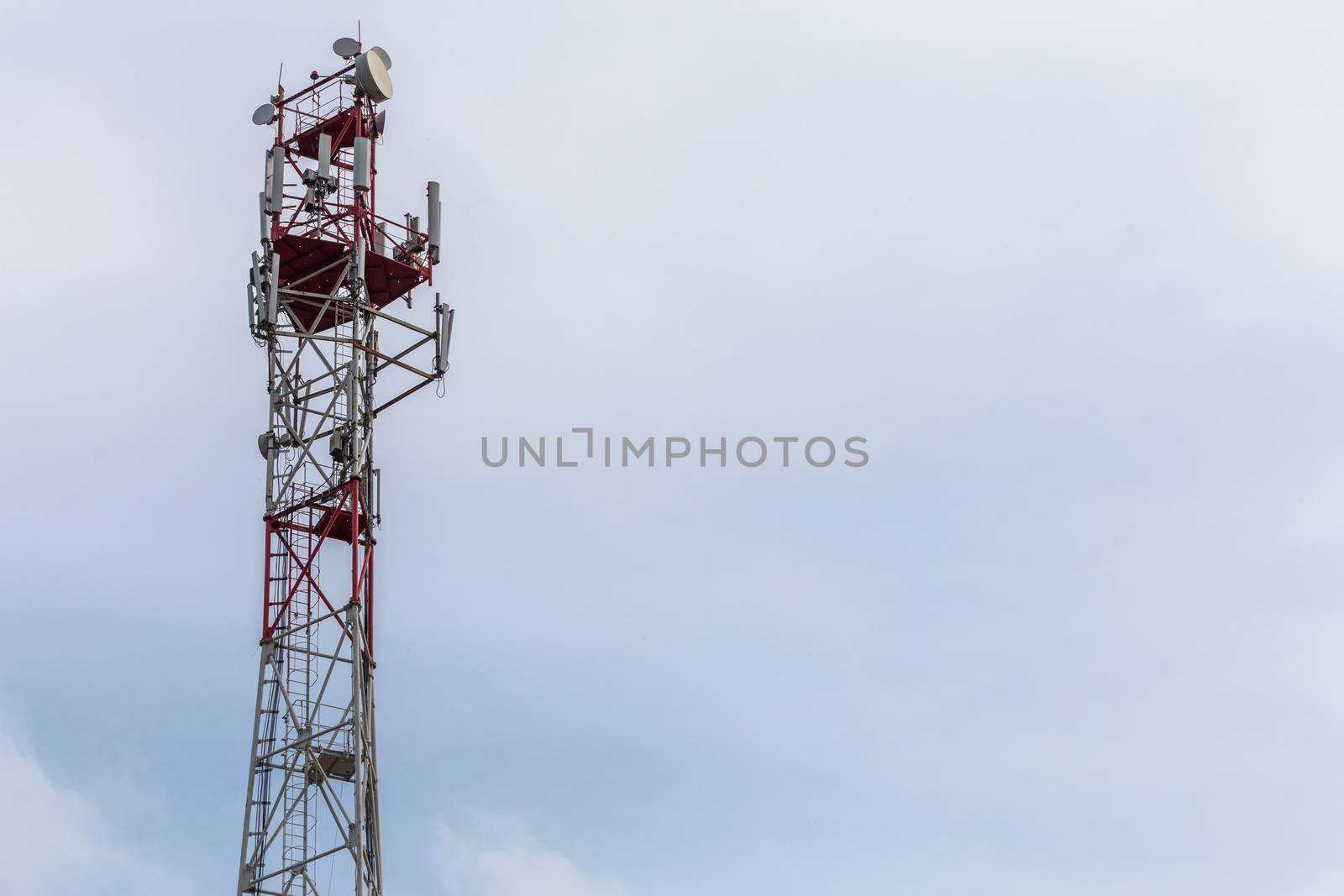 3G, 4G, 5G, wireless and cell phone telecommunication tower close-up on cloudy daylight sky background, horizontal shot with copy space